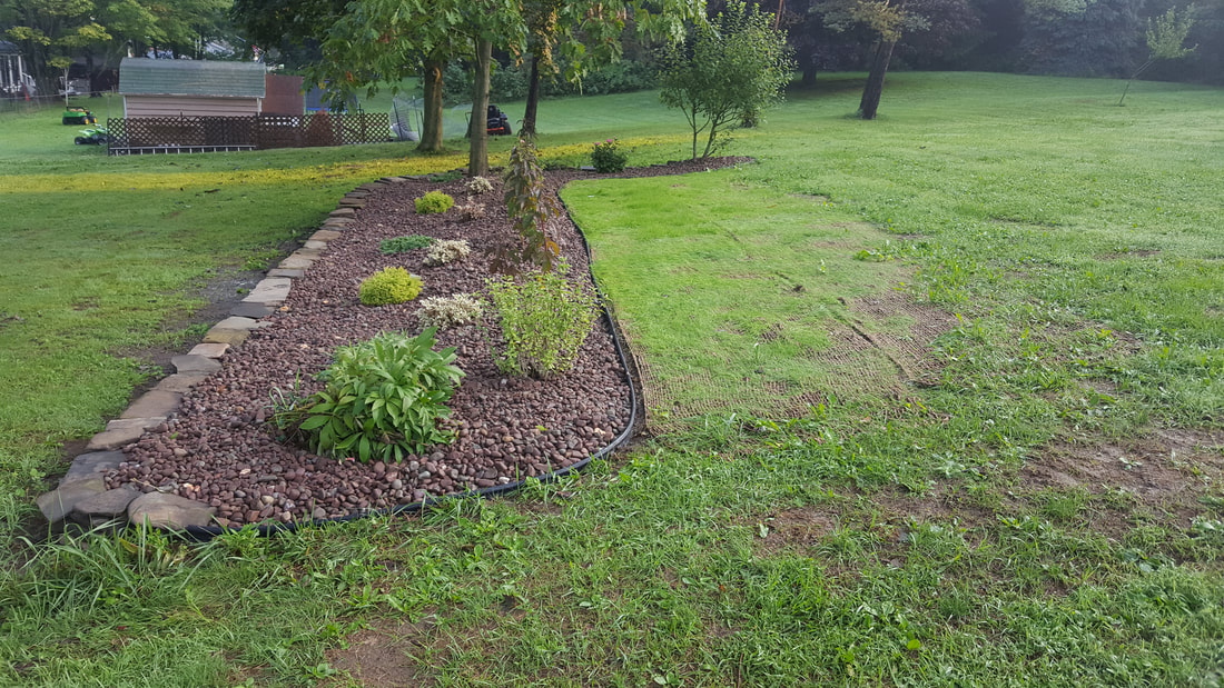 Garden bed with stone border and lava rock mulch