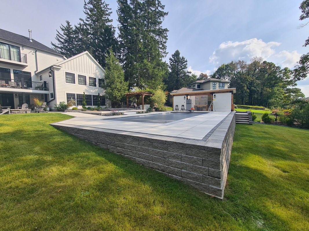 Modern paver pool deck and retaining wall in Oswego, NY