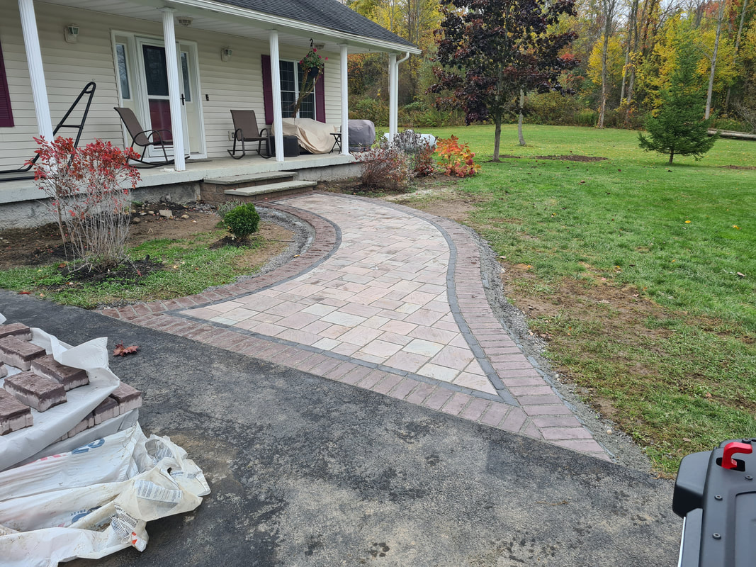 Paver walkway with brick border leading to front porch